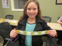 Cow Creek student holds up a finished necklace